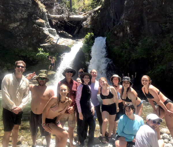 Group of students in front of river and waterfall