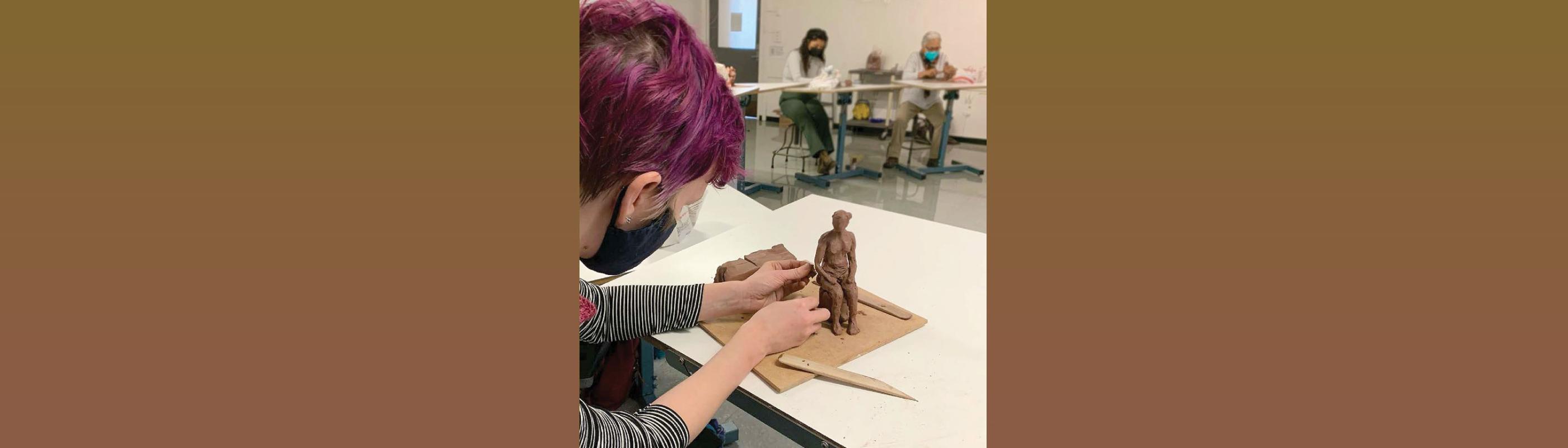 student constructing clay figure