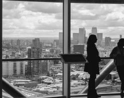 people in high-rise building looking at city view